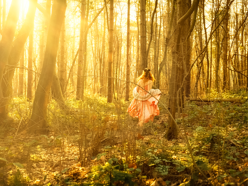 Mulher na floresta banhada por luz dourada — momento de encontro interno